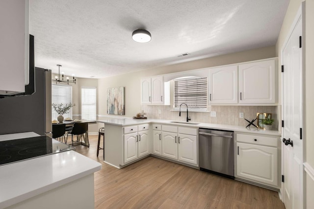 kitchen featuring pendant lighting, sink, white cabinets, kitchen peninsula, and stainless steel appliances