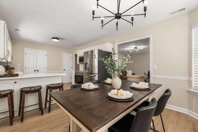 dining room with a chandelier and light wood-type flooring