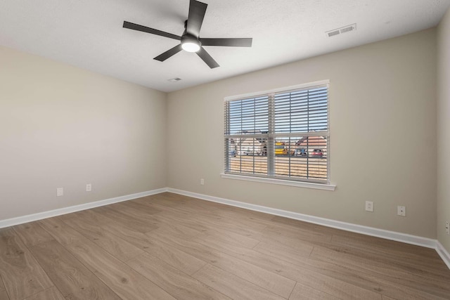 empty room with ceiling fan and light hardwood / wood-style flooring