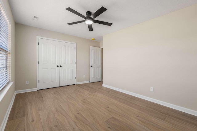 unfurnished bedroom with ceiling fan, light hardwood / wood-style floors, and a closet