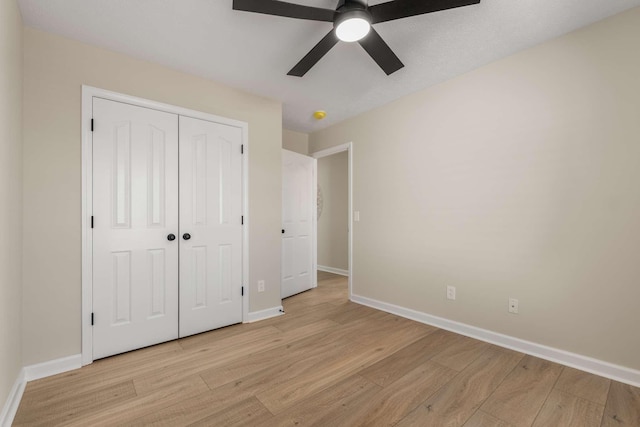 unfurnished bedroom featuring light hardwood / wood-style floors, a closet, and ceiling fan