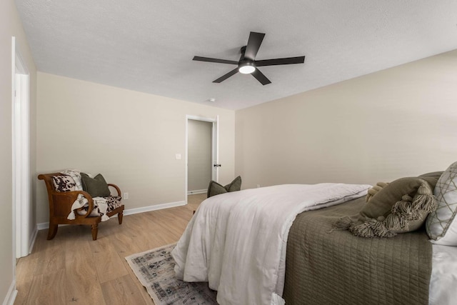 bedroom featuring ceiling fan, a textured ceiling, and light wood-type flooring