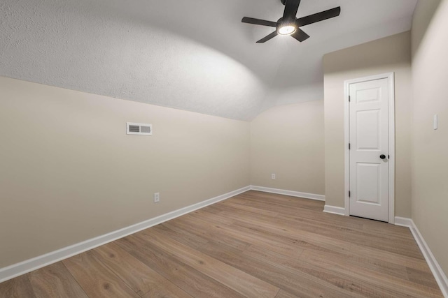 additional living space featuring ceiling fan, lofted ceiling, and light hardwood / wood-style flooring