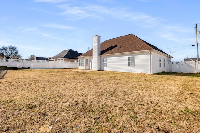 rear view of property with a lawn