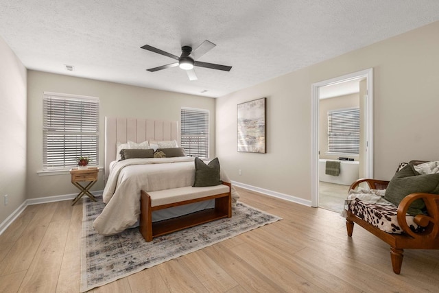 bedroom featuring ceiling fan, a textured ceiling, light wood-type flooring, and ensuite bath