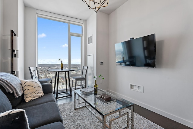 living room featuring hardwood / wood-style flooring, a chandelier, and a wall of windows