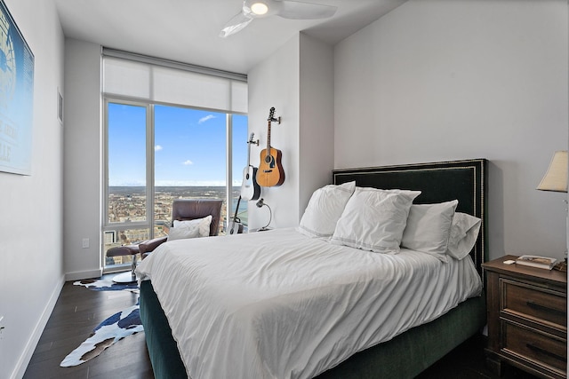 bedroom featuring expansive windows, dark hardwood / wood-style floors, and ceiling fan