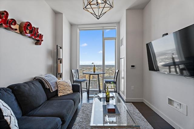 living room featuring a notable chandelier, dark wood-type flooring, and floor to ceiling windows