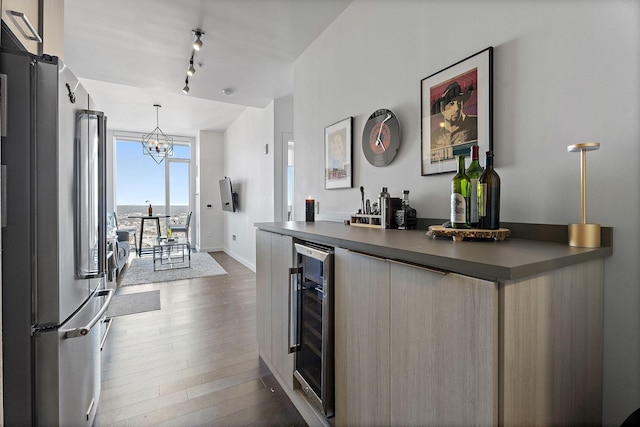 kitchen with rail lighting, high end fridge, dark hardwood / wood-style flooring, decorative light fixtures, and beverage cooler