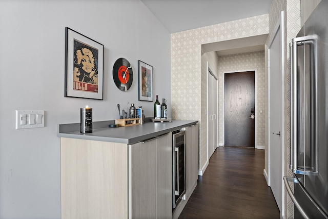 bar featuring dark wood-type flooring, high end refrigerator, and beverage cooler