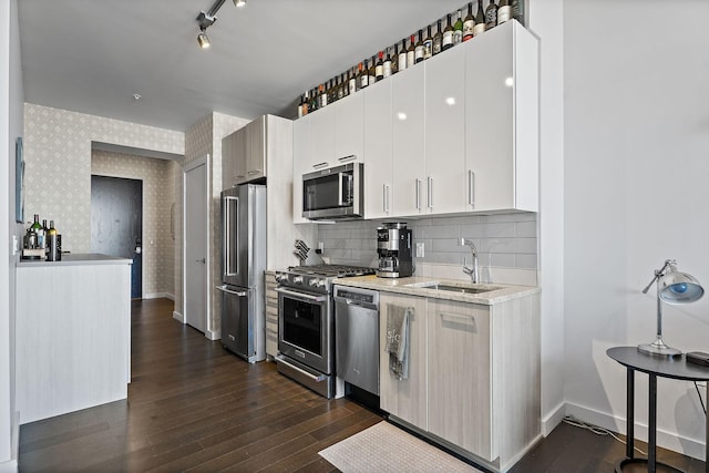 kitchen with sink, high end appliances, tasteful backsplash, white cabinets, and dark hardwood / wood-style flooring