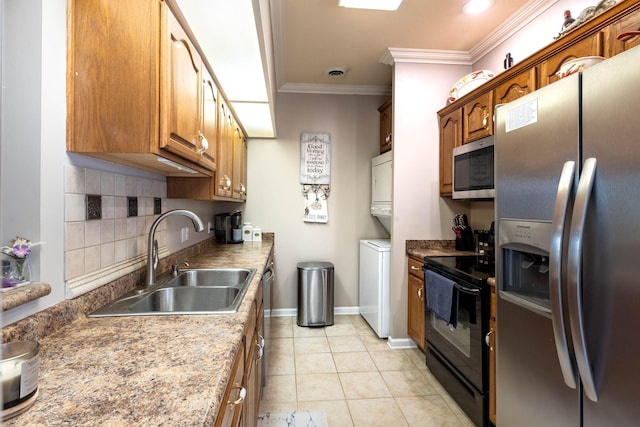 kitchen with sink, stacked washer and dryer, appliances with stainless steel finishes, backsplash, and ornamental molding