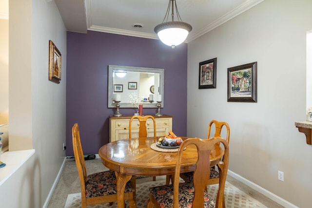 carpeted dining room with ornamental molding