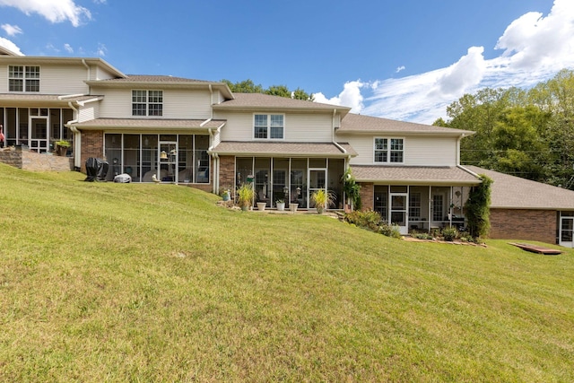 rear view of house with a yard and a sunroom