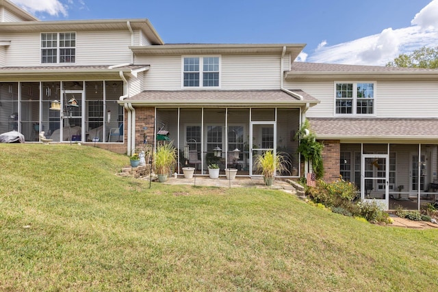 back of house featuring a lawn and a sunroom