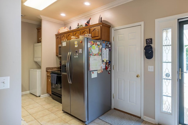 kitchen featuring crown molding, a wealth of natural light, stainless steel appliances, and stacked washer / dryer