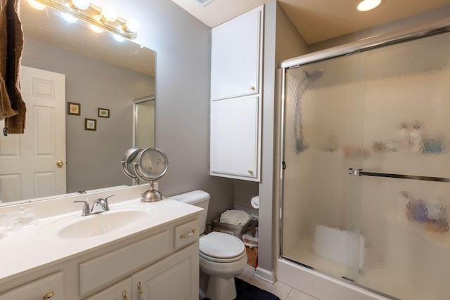 bathroom with vanity, tile patterned floors, a shower with door, and toilet