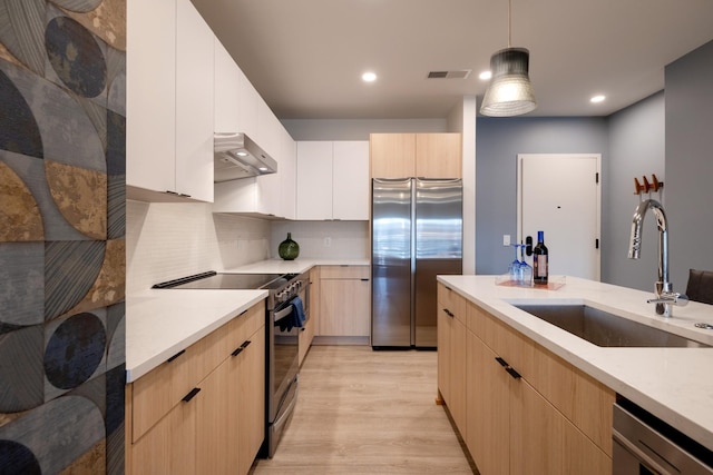 kitchen featuring sink, appliances with stainless steel finishes, hanging light fixtures, ventilation hood, and light brown cabinets