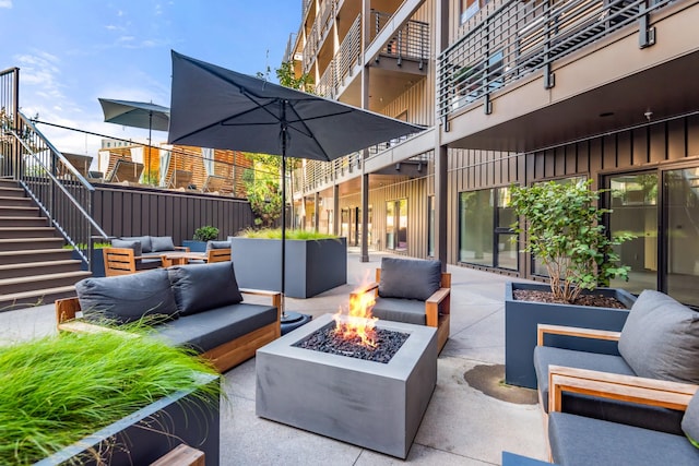 view of patio with an outdoor living space with a fire pit