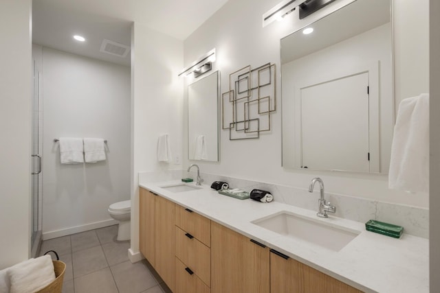 bathroom featuring vanity, toilet, a shower with shower door, and tile patterned flooring