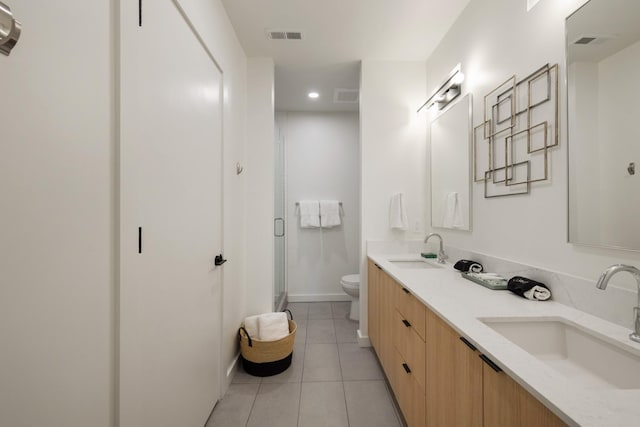 bathroom with tile patterned flooring, vanity, toilet, and walk in shower