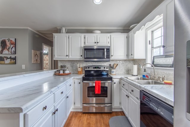 kitchen with stainless steel appliances, kitchen peninsula, and white cabinets