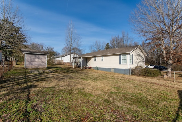 view of side of home with a storage unit and a lawn