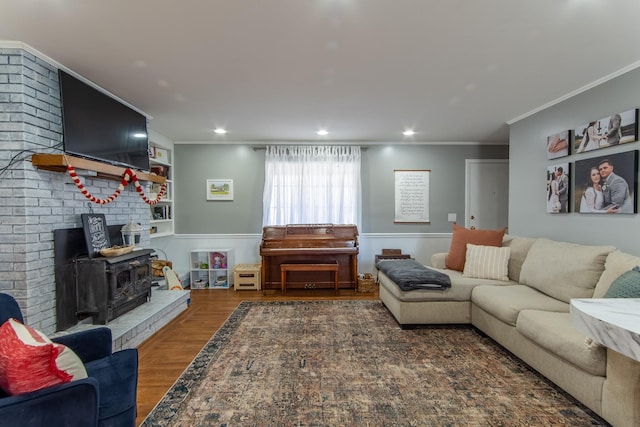 living room with crown molding, dark hardwood / wood-style floors, and a wood stove