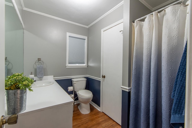 bathroom featuring wood-type flooring, ornamental molding, vanity, and toilet