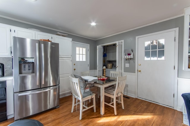 dining room with crown molding and light hardwood / wood-style flooring