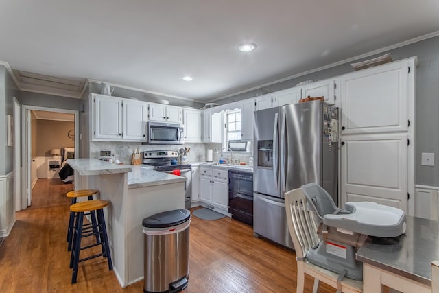 kitchen with dark hardwood / wood-style floors, sink, white cabinets, stainless steel appliances, and crown molding