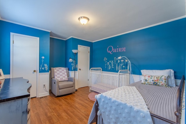 bedroom with ornamental molding and hardwood / wood-style floors