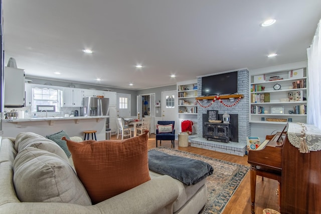 living room featuring hardwood / wood-style flooring, a wood stove, and sink