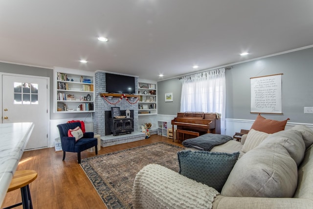 living room featuring crown molding, a wood stove, and hardwood / wood-style floors