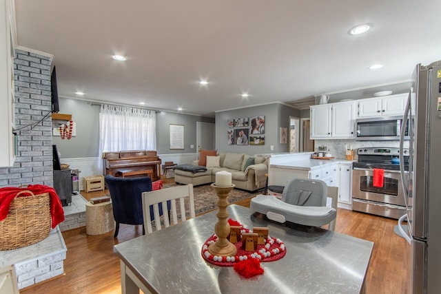 dining area featuring crown molding and light hardwood / wood-style floors