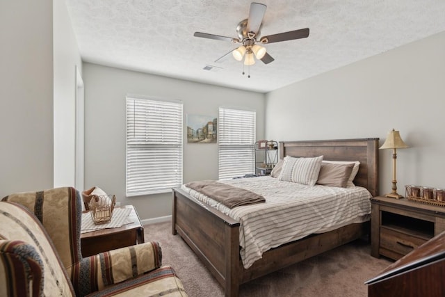 carpeted bedroom featuring ceiling fan and a textured ceiling