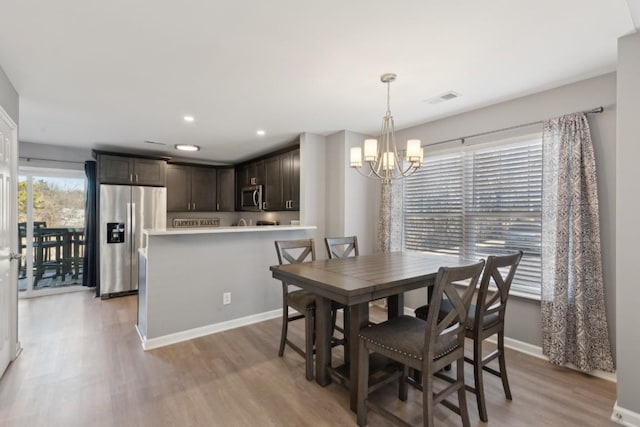 dining area featuring an inviting chandelier and light hardwood / wood-style flooring