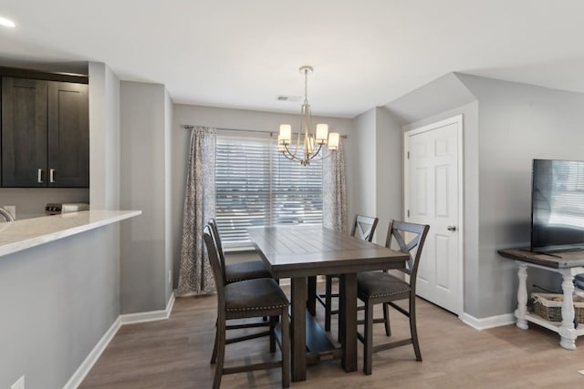 dining space with a chandelier and light wood-type flooring