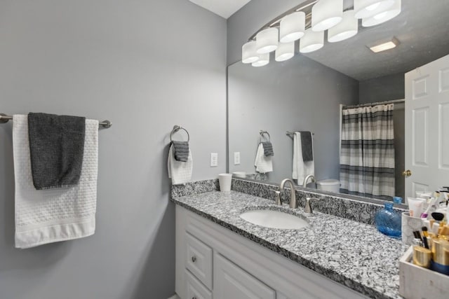 bathroom with vanity, a shower with shower curtain, and toilet