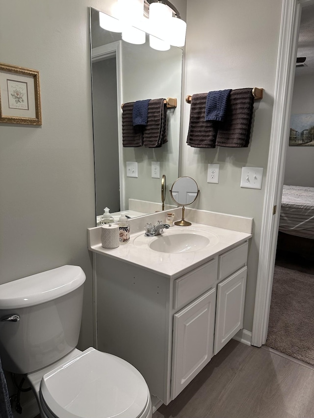 bathroom featuring vanity, wood-type flooring, and toilet