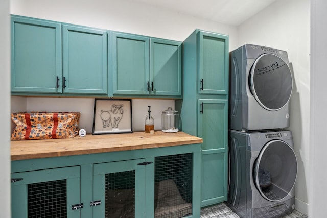 laundry room with stacked washer and dryer and cabinets