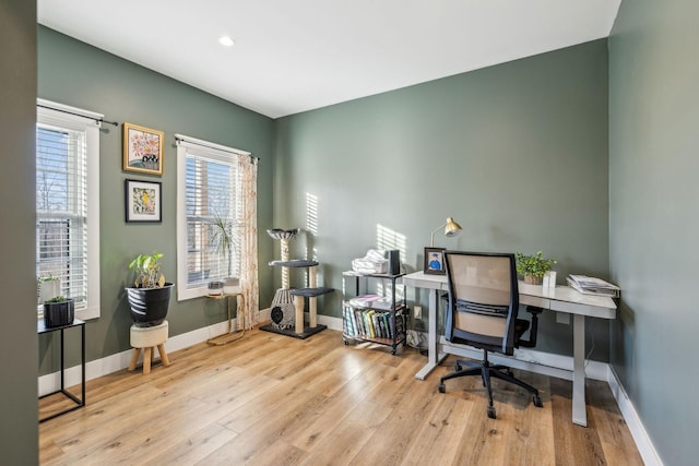 home office with a healthy amount of sunlight and light hardwood / wood-style floors