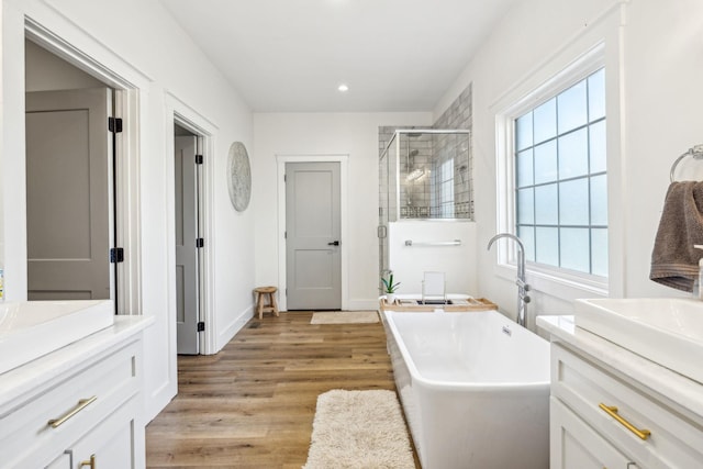 bathroom with shower with separate bathtub, hardwood / wood-style floors, and vanity