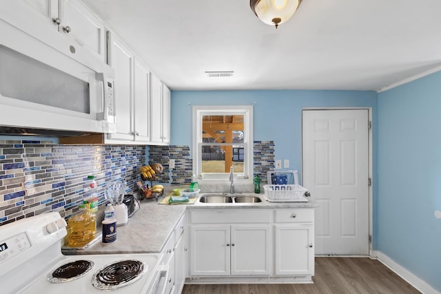 kitchen featuring sink, white appliances, light hardwood / wood-style flooring, tasteful backsplash, and white cabinets