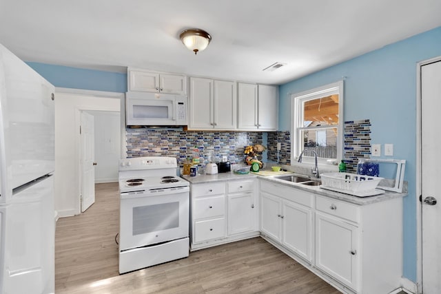 kitchen featuring tasteful backsplash, white cabinetry, sink, and white appliances