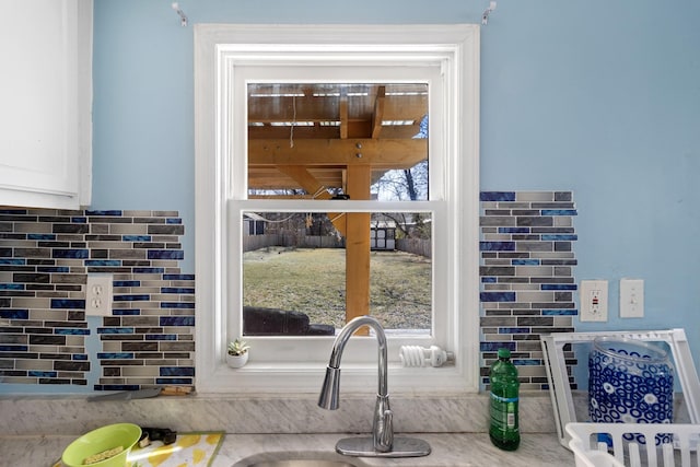 details featuring tasteful backsplash and white cabinets