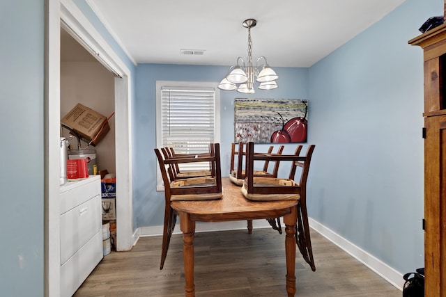 dining area featuring separate washer and dryer, dark hardwood / wood-style floors, and an inviting chandelier