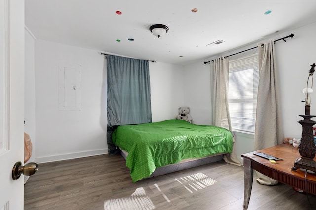 bedroom with hardwood / wood-style flooring and electric panel