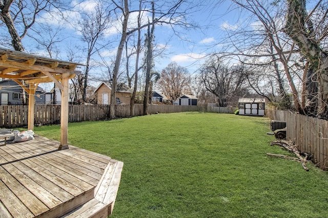 view of yard with a wooden deck and a storage unit