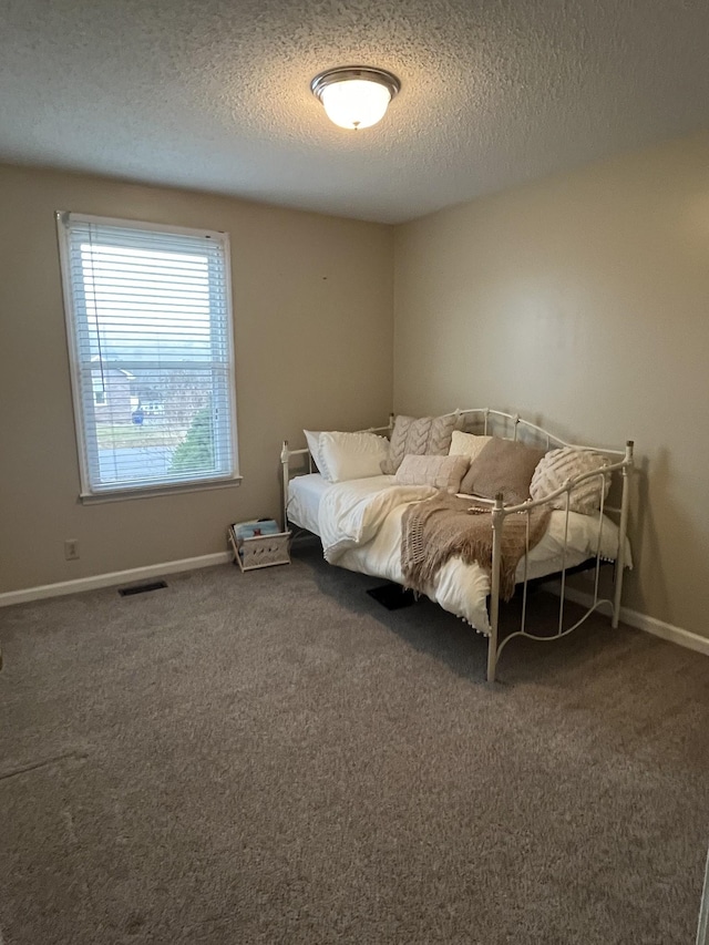 carpeted bedroom featuring a textured ceiling